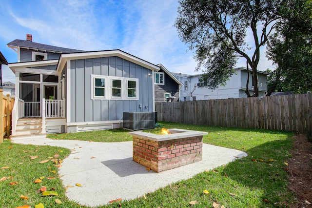 back of house with an outdoor fire pit, board and batten siding, a patio area, and a fenced backyard