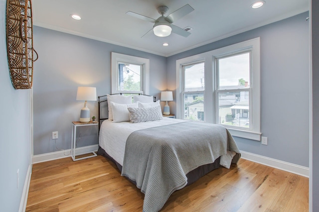 bedroom with baseboards, light wood-type flooring, and crown molding