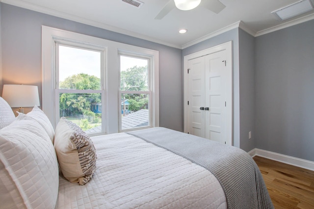 bedroom featuring visible vents, ornamental molding, ceiling fan, wood finished floors, and baseboards