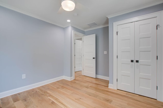 unfurnished bedroom with visible vents, light wood-style flooring, ornamental molding, ceiling fan, and baseboards