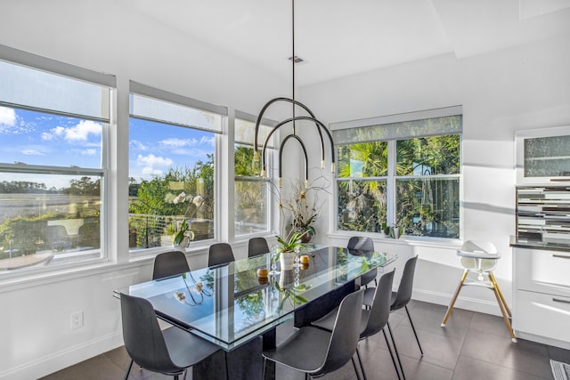 dining room featuring dark tile patterned flooring and a healthy amount of sunlight