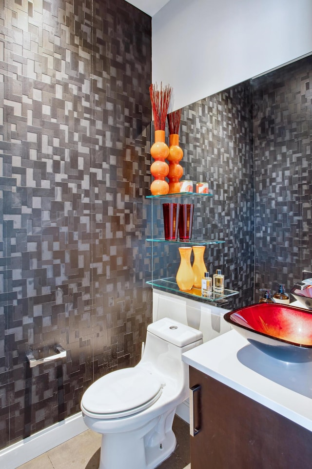 bathroom with toilet, tile patterned flooring, tile walls, and vanity