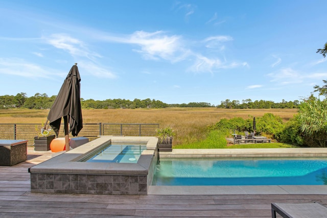 view of pool featuring a rural view, a deck, and an in ground hot tub