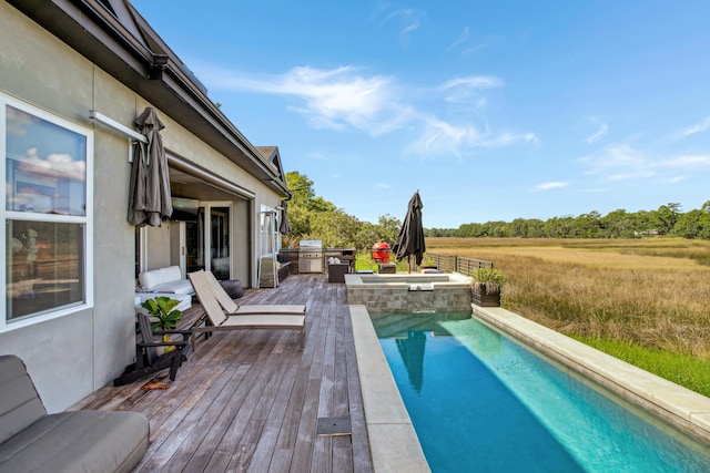 view of swimming pool featuring an in ground hot tub, a deck, grilling area, and a rural view