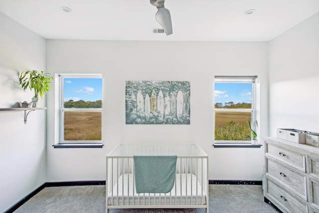 carpeted bedroom with a nursery area and multiple windows