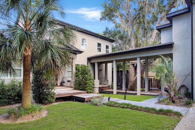 rear view of property with a yard and a wooden deck