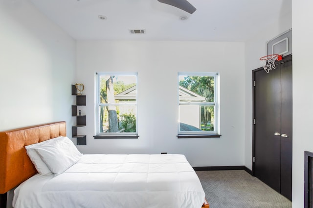 carpeted bedroom featuring ceiling fan and multiple windows