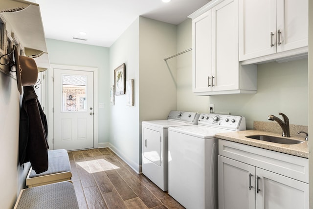 washroom featuring washer and clothes dryer, cabinets, sink, and dark wood-type flooring