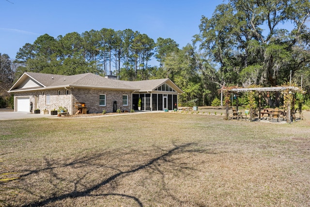 view of front of property featuring a sunroom, a garage, and a front lawn