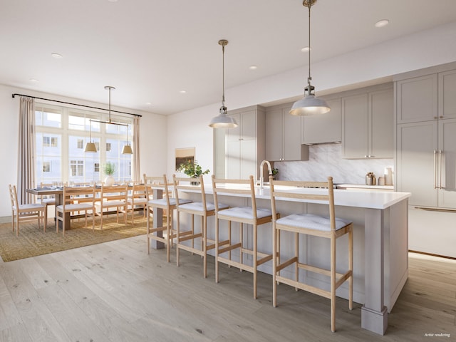 kitchen featuring tasteful backsplash, gray cabinets, light countertops, and light wood-type flooring