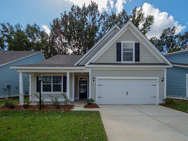 craftsman inspired home with a front lawn, driveway, and a garage