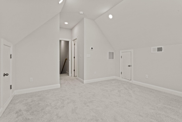 additional living space featuring vaulted ceiling, visible vents, and light colored carpet