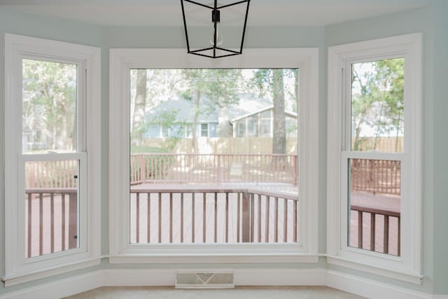 unfurnished sunroom with a notable chandelier and plenty of natural light