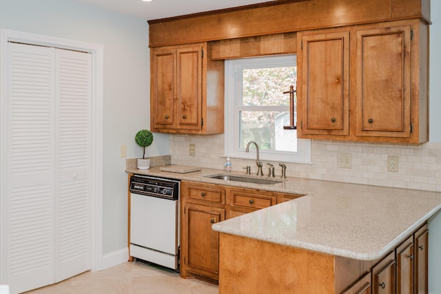 kitchen featuring dishwasher, sink, decorative backsplash, light tile patterned floors, and kitchen peninsula