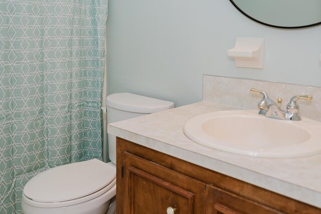 bathroom with a shower with curtain, vanity, and toilet