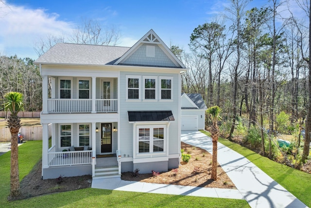 view of front of property featuring a balcony, a standing seam roof, covered porch, concrete driveway, and metal roof