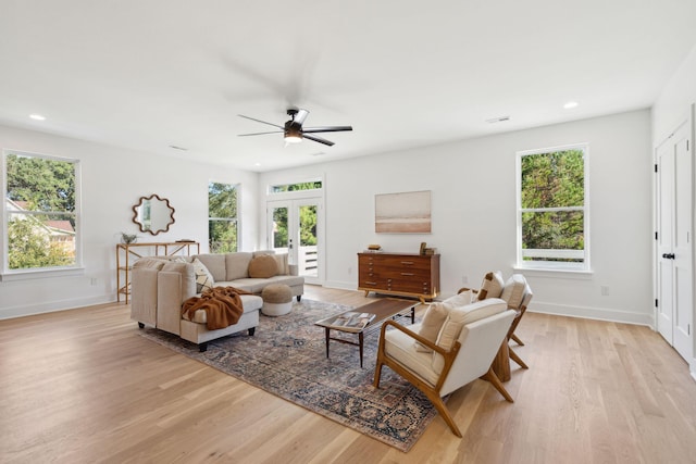 living room with light hardwood / wood-style flooring, a healthy amount of sunlight, and french doors