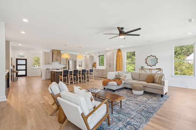 living room with ceiling fan and light wood-type flooring