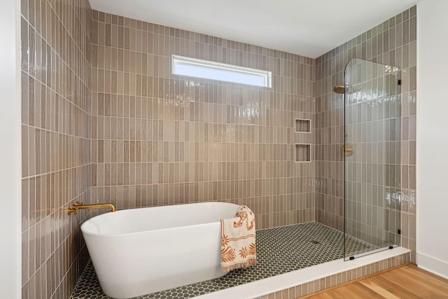 bathroom featuring wood-type flooring and shower with separate bathtub