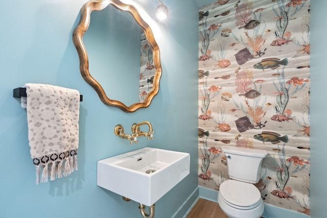 bathroom featuring toilet, wood-type flooring, and sink