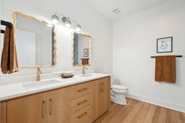 bathroom featuring wood-type flooring, vanity, and toilet