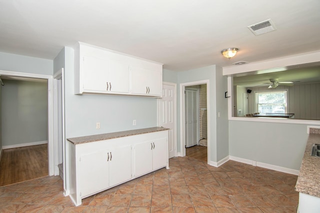 kitchen featuring white cabinetry and ceiling fan