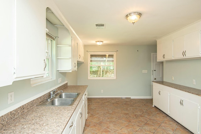 kitchen featuring white cabinets and sink