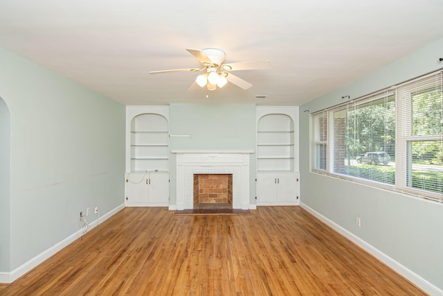 unfurnished living room featuring ceiling fan, a fireplace, and hardwood / wood-style flooring