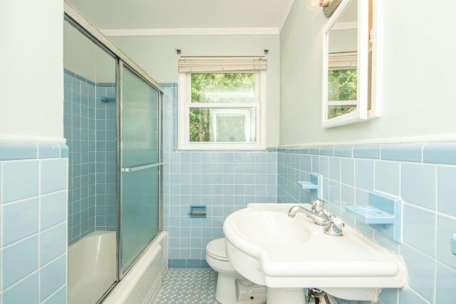 full bathroom with tile patterned floors, toilet, enclosed tub / shower combo, tile walls, and ornamental molding