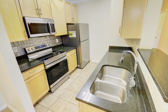 kitchen with backsplash, stainless steel appliances, sink, light tile patterned floors, and light brown cabinets