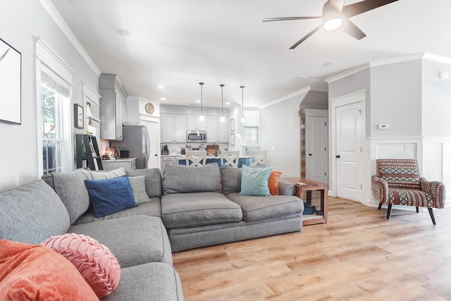 living room with ceiling fan, light hardwood / wood-style floors, and crown molding