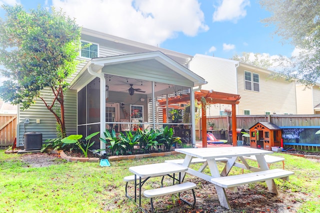 back of property with a sunroom, a lawn, a pergola, ceiling fan, and a patio area