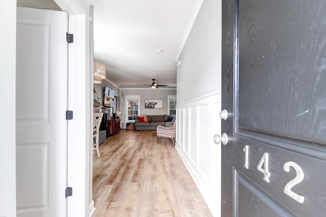 hall with crown molding and light wood-type flooring