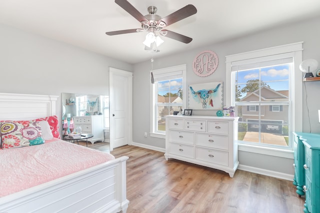 bedroom with light hardwood / wood-style flooring, multiple windows, and ceiling fan