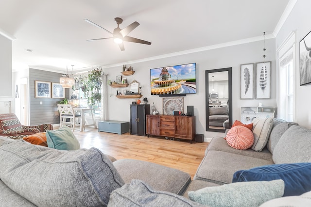 living room with hardwood / wood-style floors, ceiling fan, ornamental molding, and wooden walls