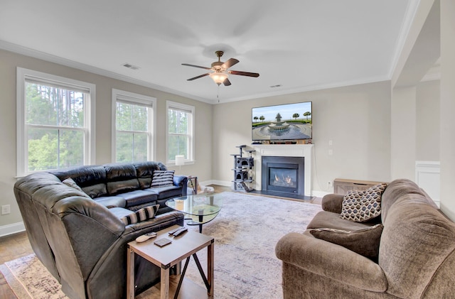 living room featuring hardwood / wood-style floors, ceiling fan, and crown molding