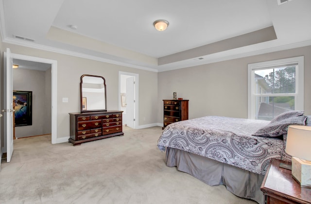 bedroom with ornamental molding, carpet, and a tray ceiling