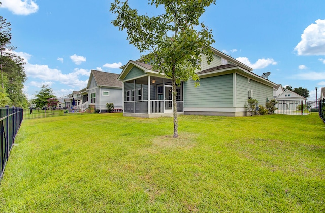 back of property with a sunroom and a lawn