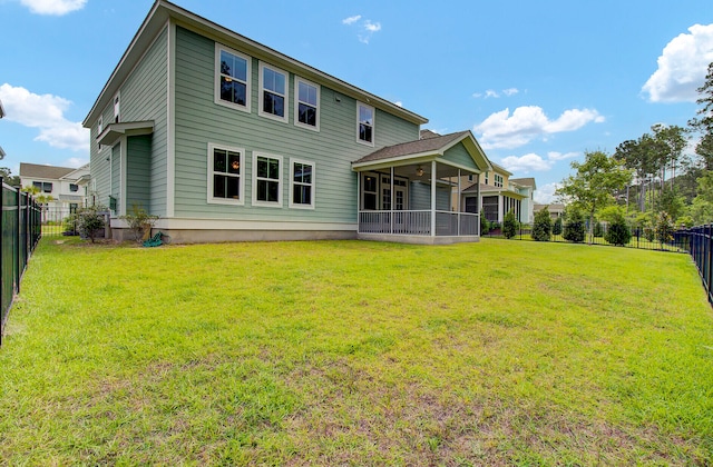 back of house featuring a yard and a sunroom