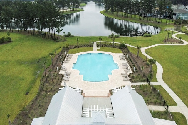 view of swimming pool featuring a water view and a yard