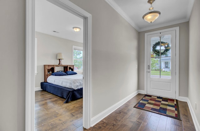 foyer entrance with crown molding and dark hardwood / wood-style flooring