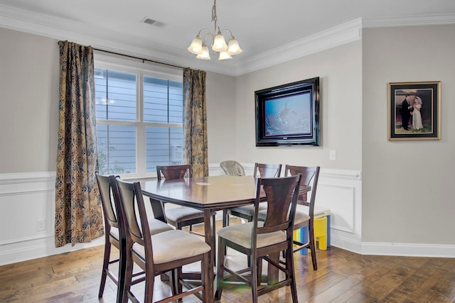 dining room with ornamental molding, a healthy amount of sunlight, an inviting chandelier, and hardwood / wood-style floors