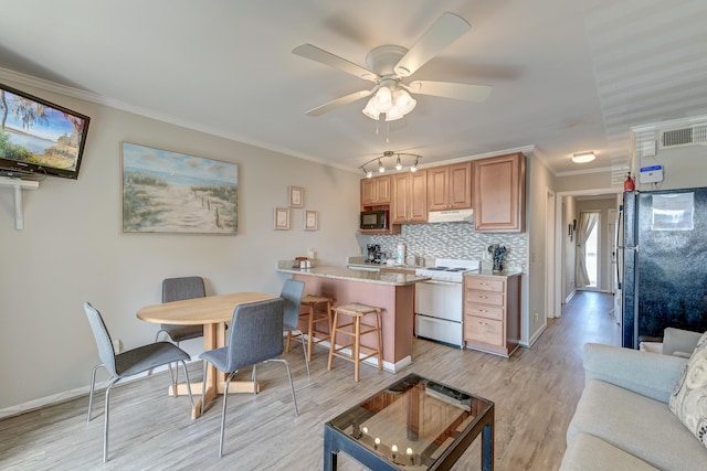 kitchen featuring under cabinet range hood, visible vents, black appliances, and crown molding