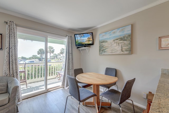 dining space with baseboards, wood finished floors, and ornamental molding