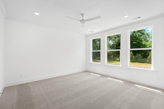 spare room featuring light colored carpet and ceiling fan