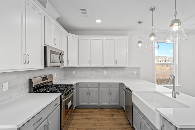 kitchen featuring dark wood-type flooring, backsplash, sink, and appliances with stainless steel finishes