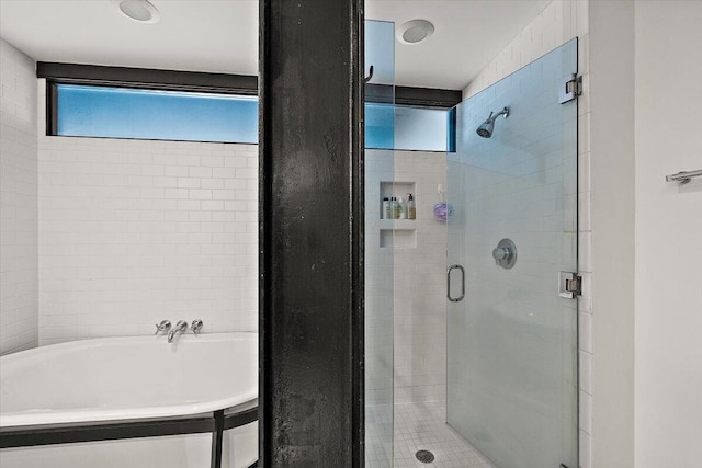 bathroom featuring a soaking tub and a stall shower