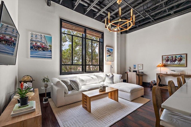 living area featuring an inviting chandelier, a high ceiling, and hardwood / wood-style floors