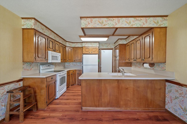 2912 Doncaster Dr, Charleston, SC 29414 - kitchen featuring white appliances, wallpapered walls, light wood-type flooring, a peninsula, and brown cabinetry
