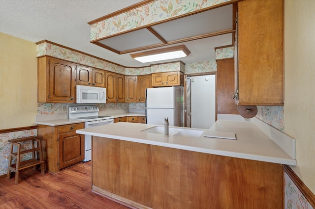 2912 Doncaster Dr, Charleston, SC 29414 - kitchen with white appliances, a sink, light wood-type flooring, brown cabinetry, and a peninsula